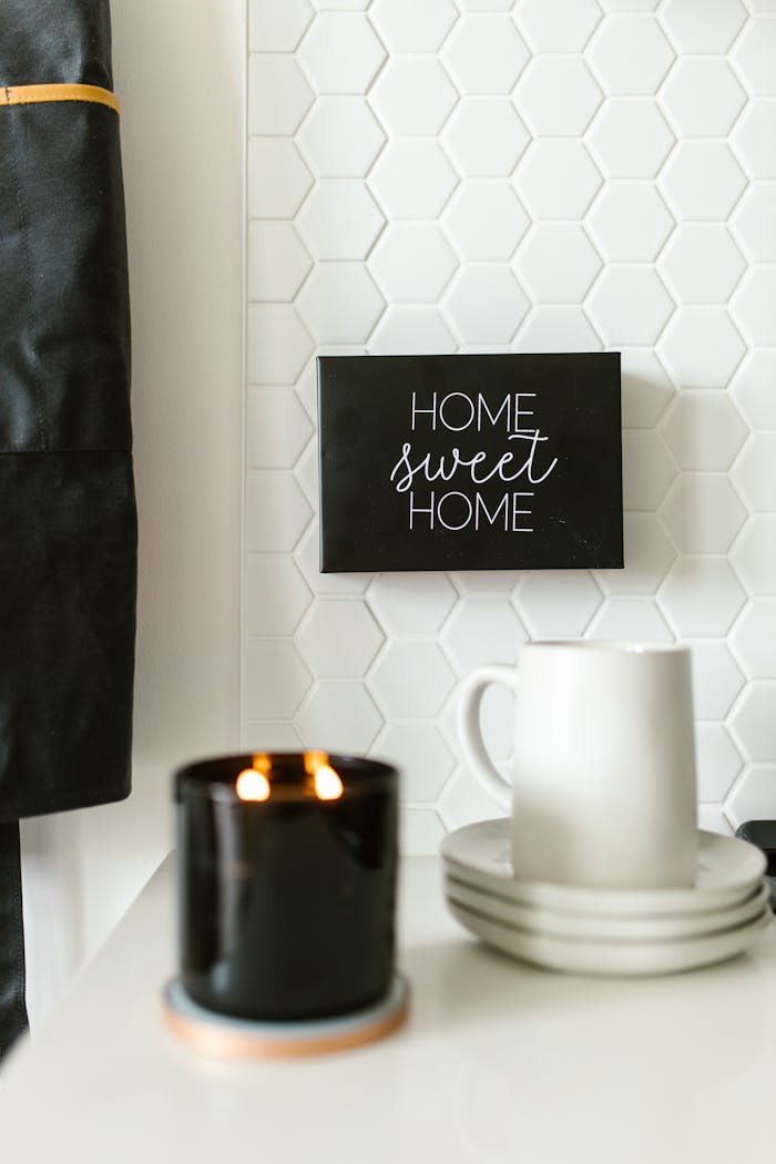 A warm, inviting scene with a candle and mug set against a stylish backsplash, perfect for home decor inspiration.